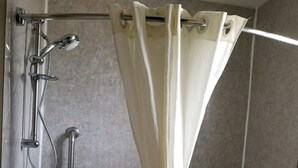 A modern bathroom with a bathtub, shower, and grab bars. - Budget Inn Express Douglas (Douglas)