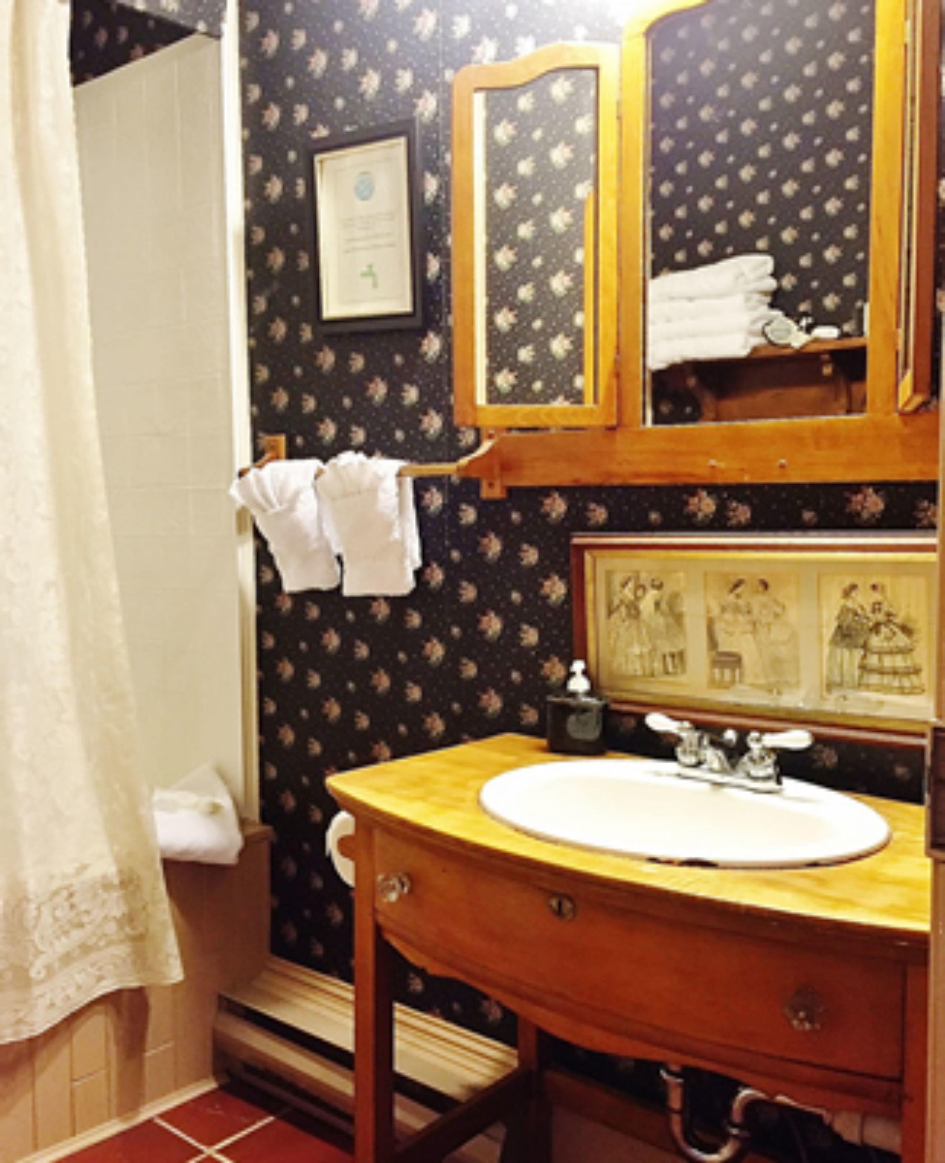 A bathroom with a wooden vanity, a sink, a mirror, and a framed picture above the mirror.