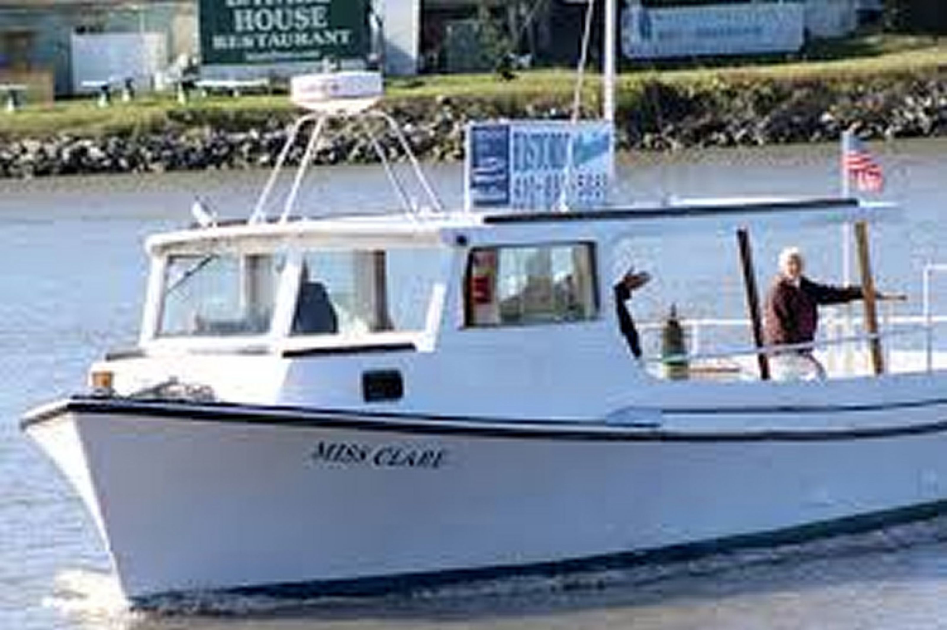 A boat named "Miss Clare" on water.