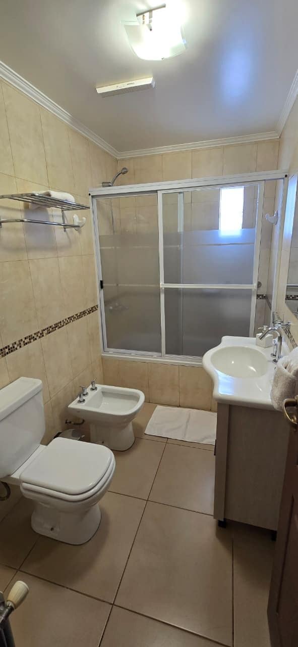 A bathroom with a toilet, bidet, and a shower enclosure.