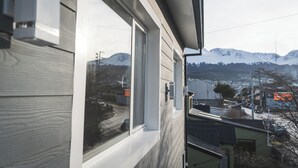 A view from a window of a building with a mountain backdrop. - La Posta Apart (Ushuaia)