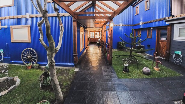 A corridor with a wooden ceiling and blue walls, leading to a door at the end. - La Posta Apart (Ushuaia)