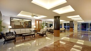 A spacious lobby with a high ceiling, marble flooring, and modern furnishings including sofas and armchairs. - Hotel Bonampak (Cancun)