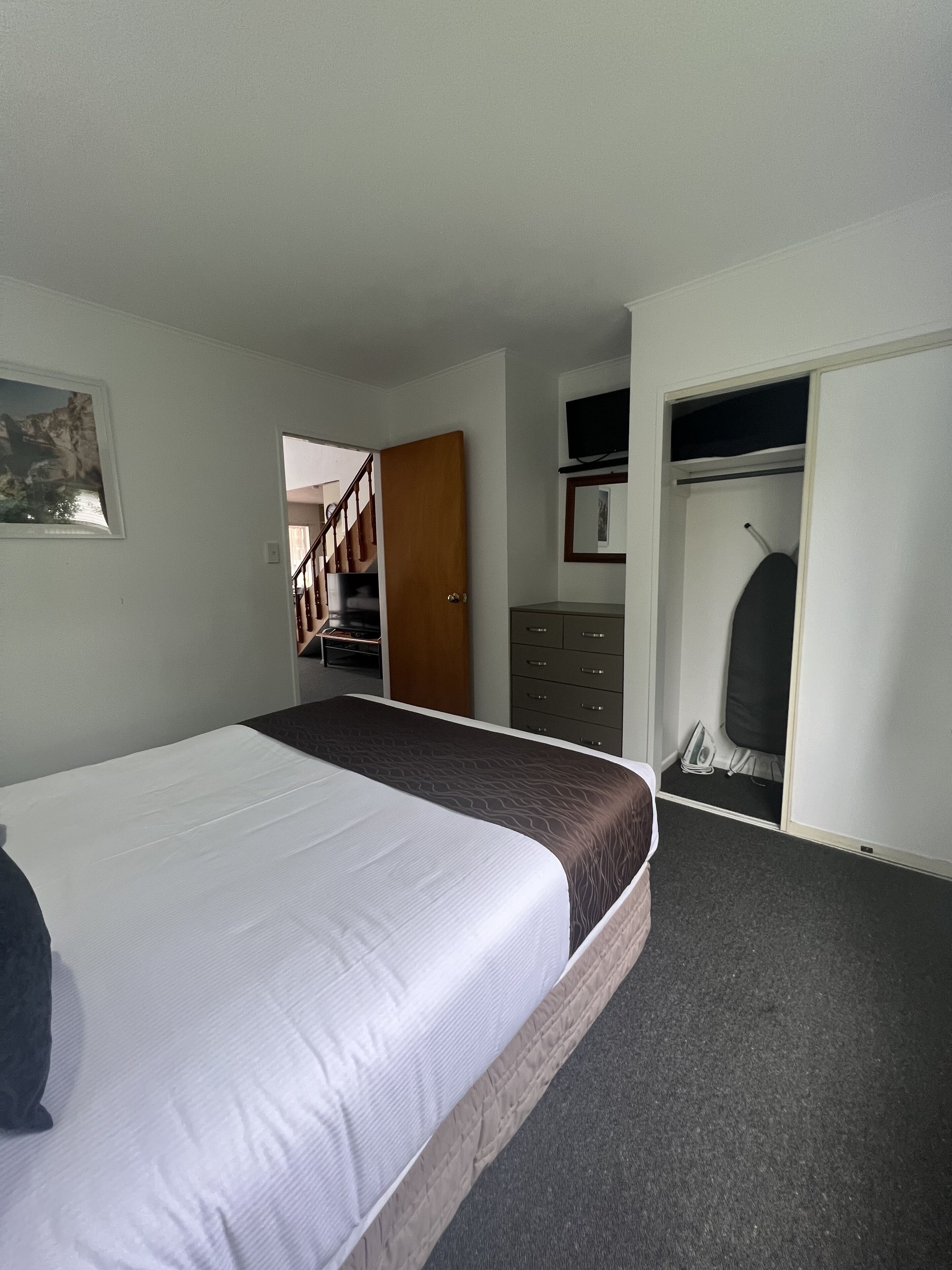 Ein Schlafzimmer mit Bett, Kleiderschrank, Schreibtisch und Stuhl.