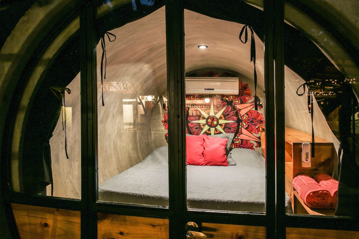Una habitación acogedora y rústica con una cama, un detalle decorativo en la pared y un aparador de madera.