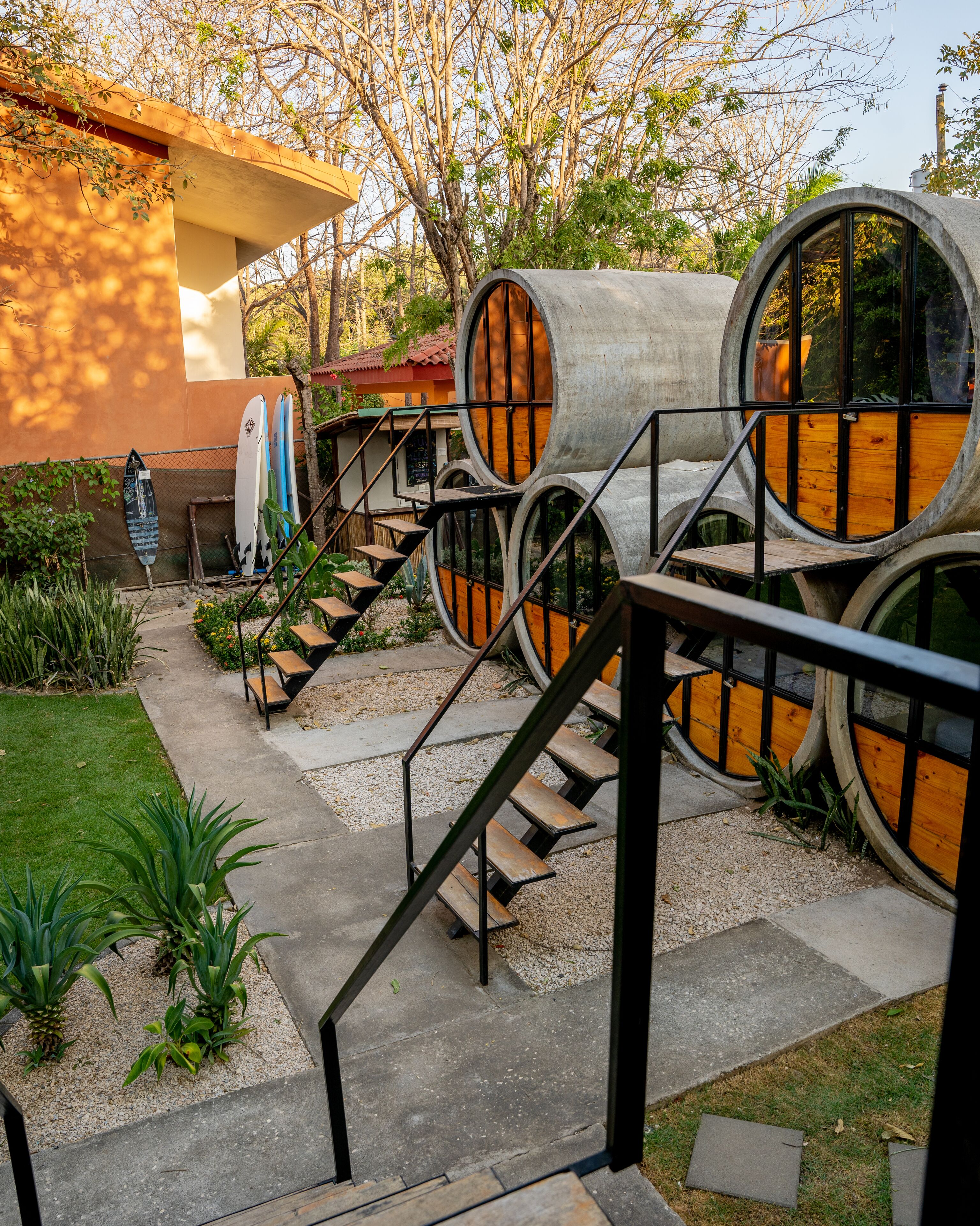 Un edificio con un diseño arquitectónico singular que presenta estructuras cilíndricas y una escalera que conduce a un nivel superior.