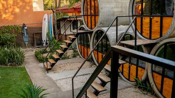 Un edificio con un diseño arquitectónico singular que presenta estructuras cilíndricas y una escalera que conduce a un nivel superior.