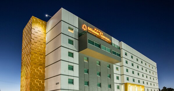 A hotel with a modern design, featuring a prominent 'Hotel Express' sign and a distinctive golden facade.