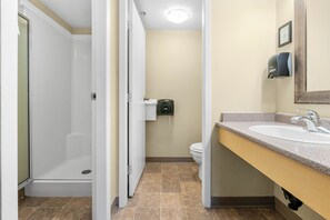 A bathroom with a shower, toilet, and sink.