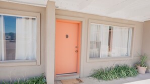 A building with a beige exterior, an orange door marked with the number 9, and a doormat. - Lamplighter Lodge (Panguitch)