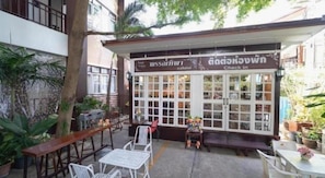 A cafe with outdoor seating and a check-in counter. - Phanthipha Residence (Khon Kaen)