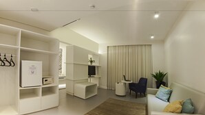 A modern living room with a sofa, a coffee table, a TV, and a bookshelf.
