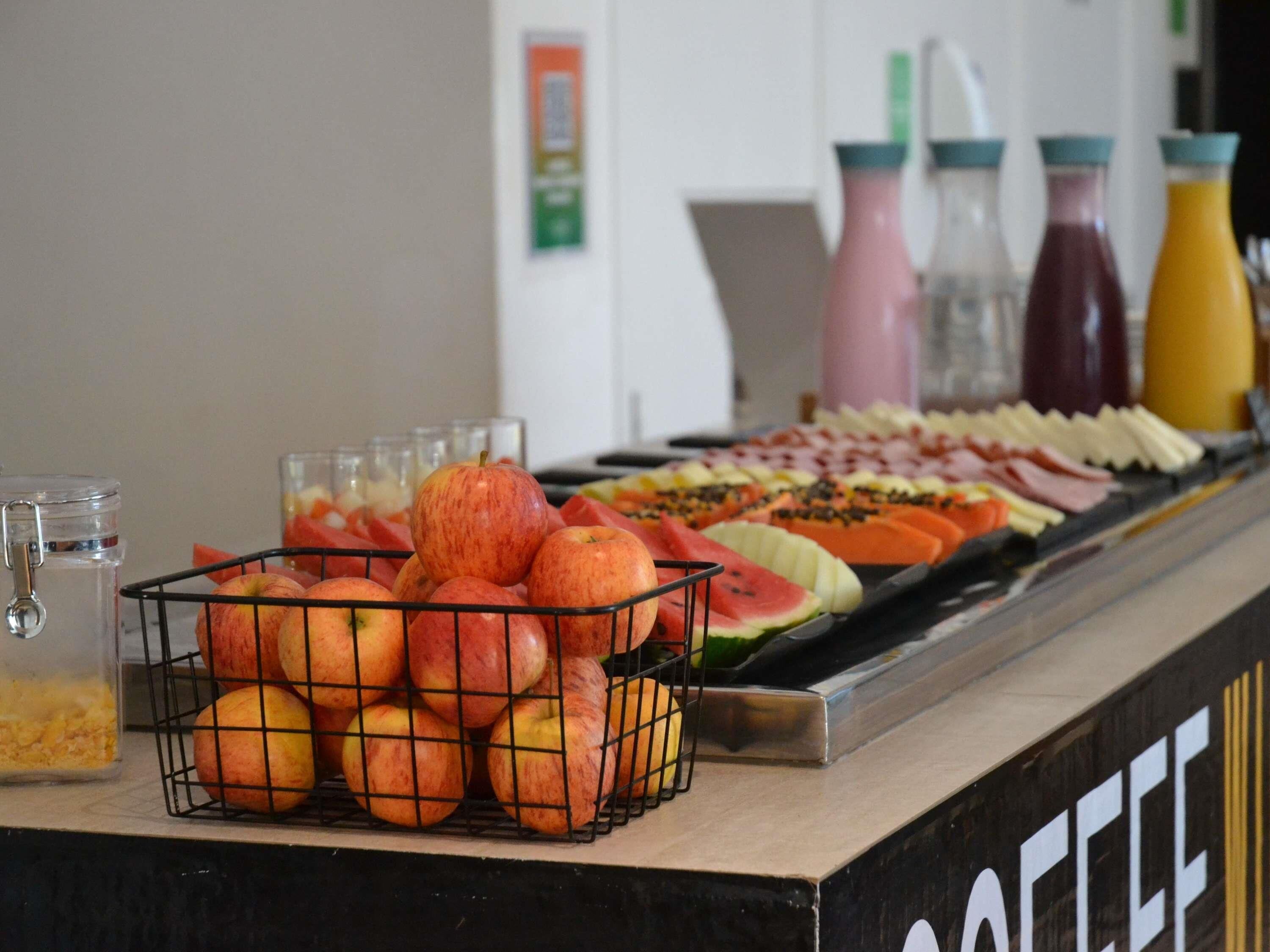 Un buffet con frutta, verdura e diverse bevande.