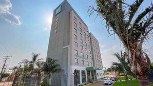 A tall hotel building with a modern design, featuring multiple floors and a prominent entrance.