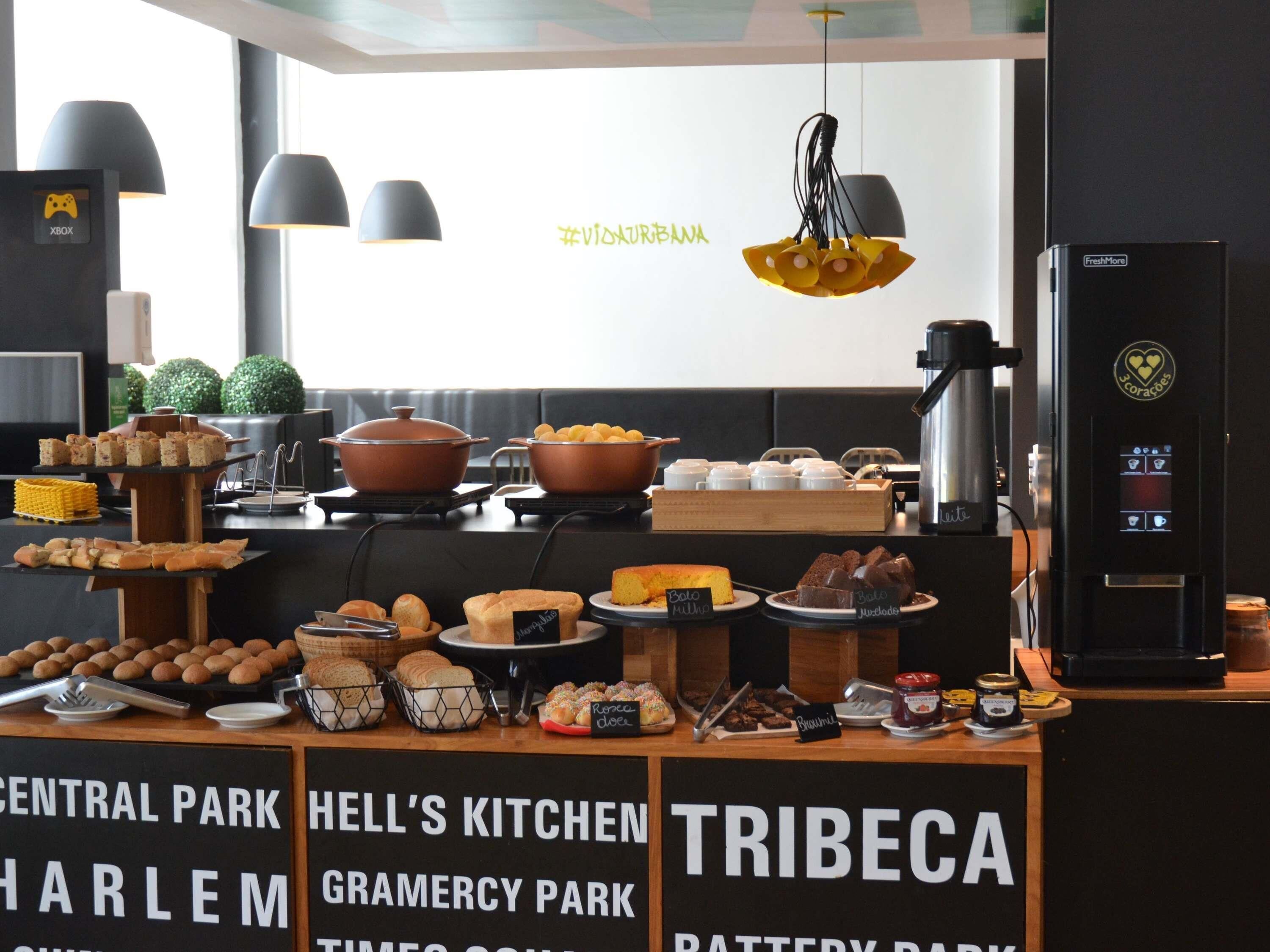 Disposição de buffet com diversos alimentos e uma máquina de café.