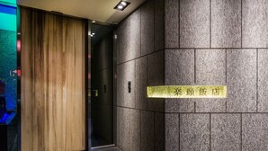 A modern interior with a wooden panel wall and a sign indicating a restaurant.