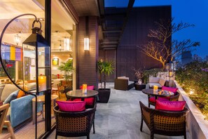 An outdoor seating area with wicker furniture, candles, and potted plants. - Lacle Hotel - Luzhou Taipei (New Taipei City)