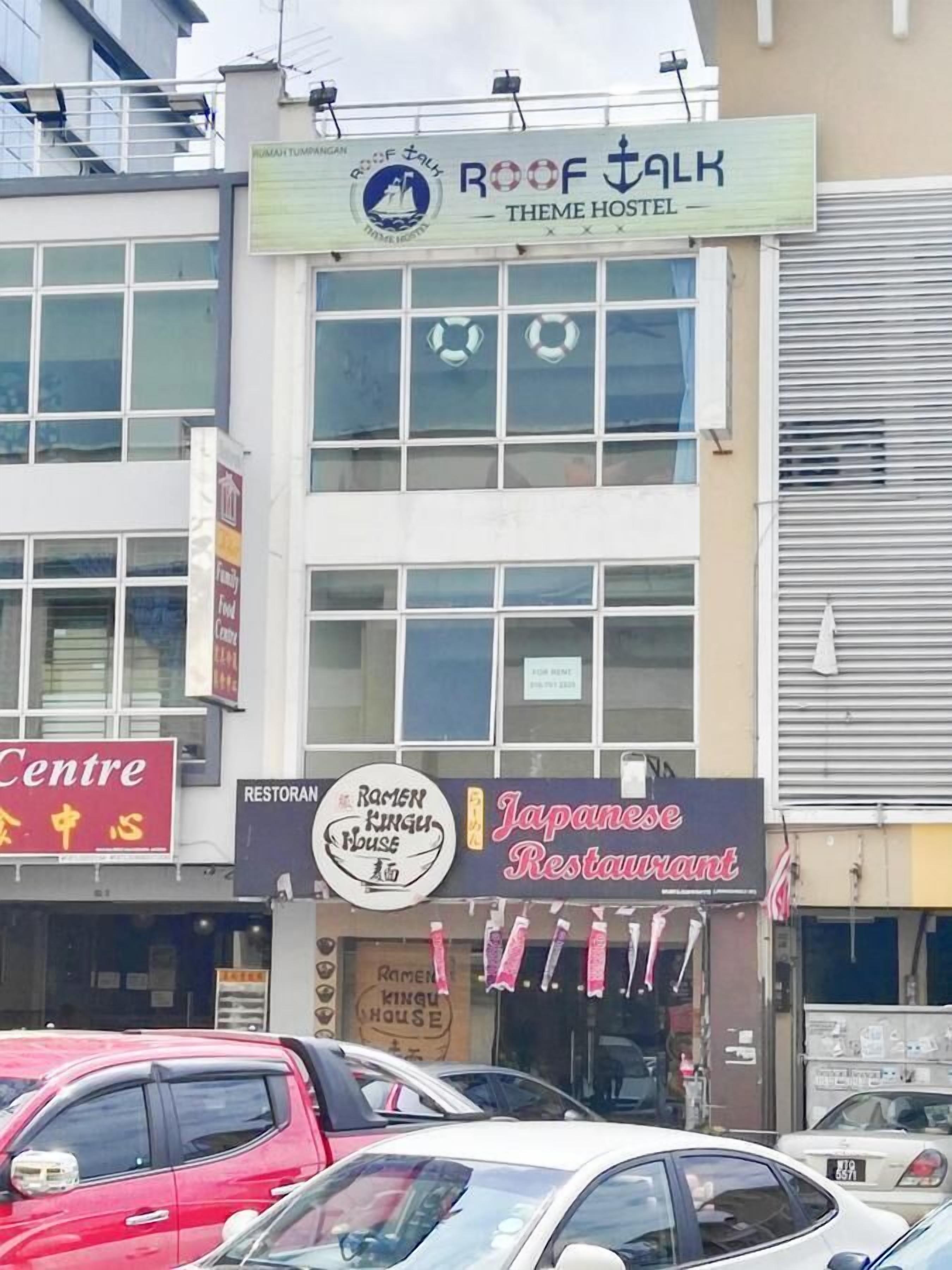 A building with signs for 'Roof Talk Theme Hostel' and 'Japanese Restaurant'.