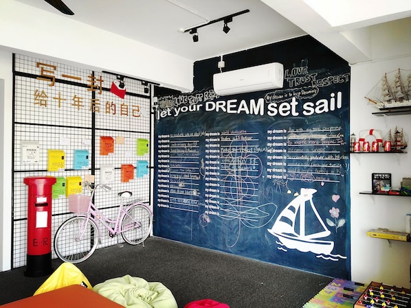 A room with a chalkboard wall displaying various dreams and a bicycle.