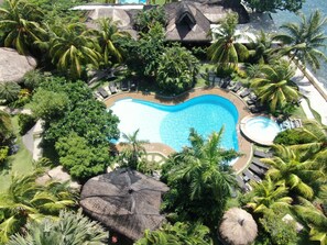 A resort with a heart-shaped pool surrounded by lush greenery and palm trees. - Thalatta Resort (Zamboanguita)