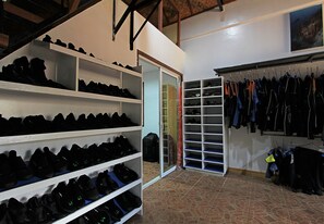 A shoe storage area with shelves and racks, a mirrored closet door, and a tiled floor. - Thalatta Resort (Zamboanguita)