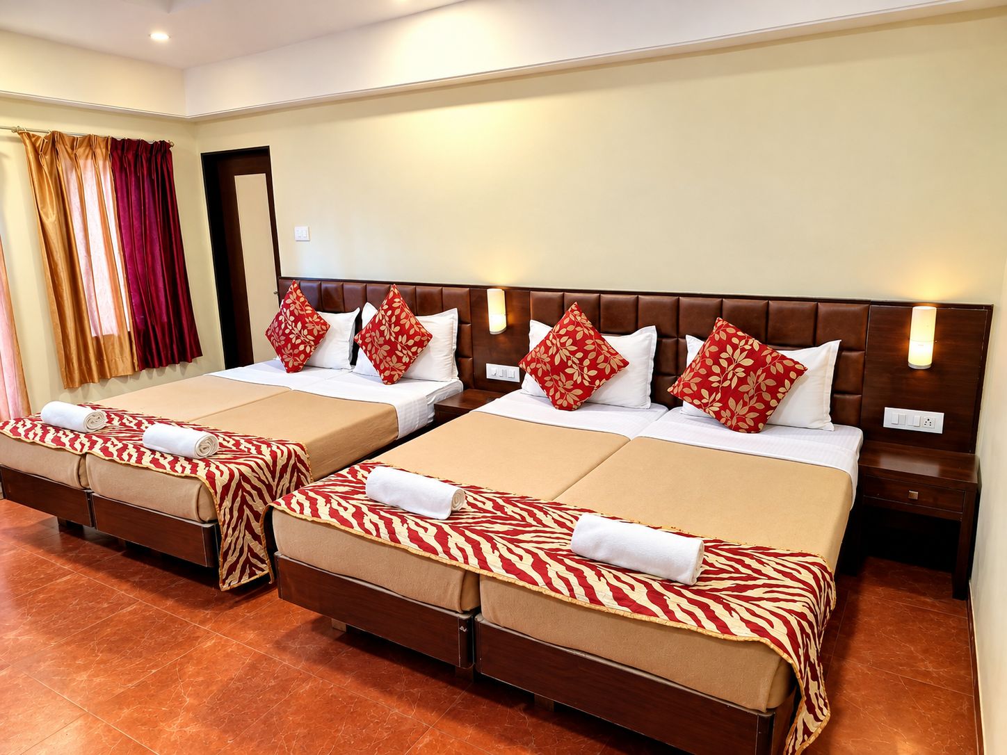 A hotel room with two beds, each with a headboard, and a pair of nightstands.