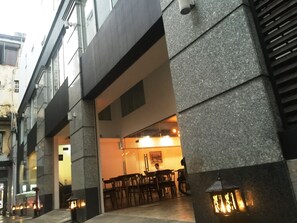 A building with a stone facade, a covered outdoor seating area with tables and chairs, and a visible entrance. - Diamond Suite Hai Ba Trung (Ho Chi Minh City)