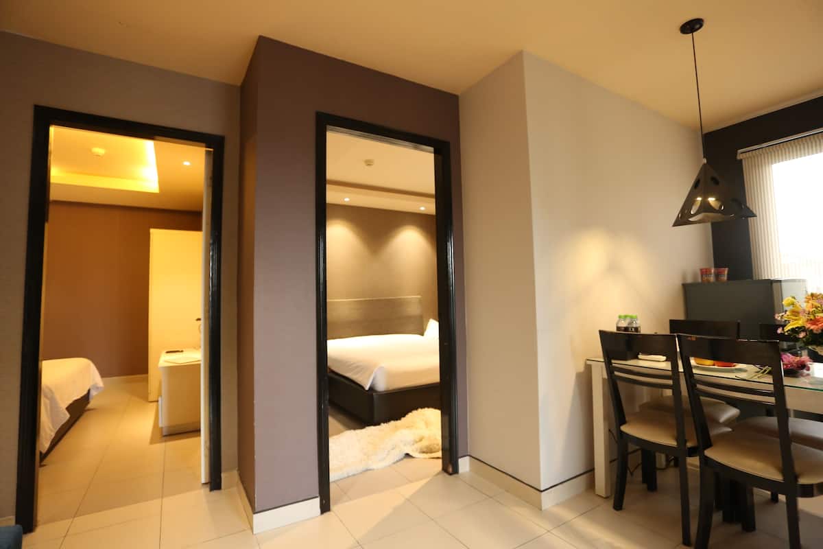 Una habitación de hotel moderna con cama, mesita de noche y escritorio con sillas.