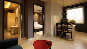 Una habitación de hotel moderna con cama, escritorio y zona de comedor.