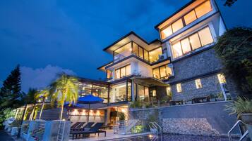 Vista frontal de la propiedad por la tarde o noche