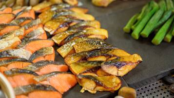 Un assortiment de légumes grillés, notamment des carottes et des asperges, préparés sur un grill.