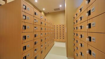 A row of wooden lockers with numbered tags, indicating a secure storage area, likely in a hotel or similar establishment.
