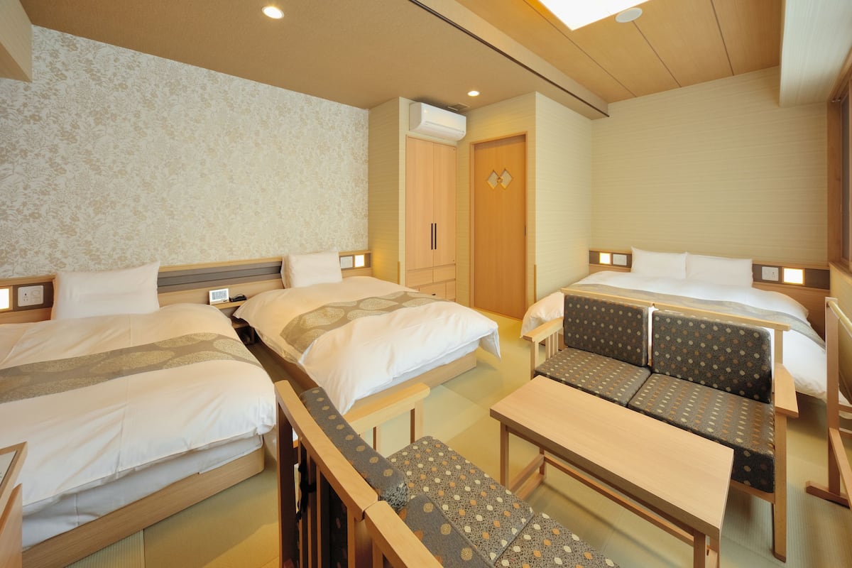 Una habitación de hotel con dos camas, un sofá y una mesita.