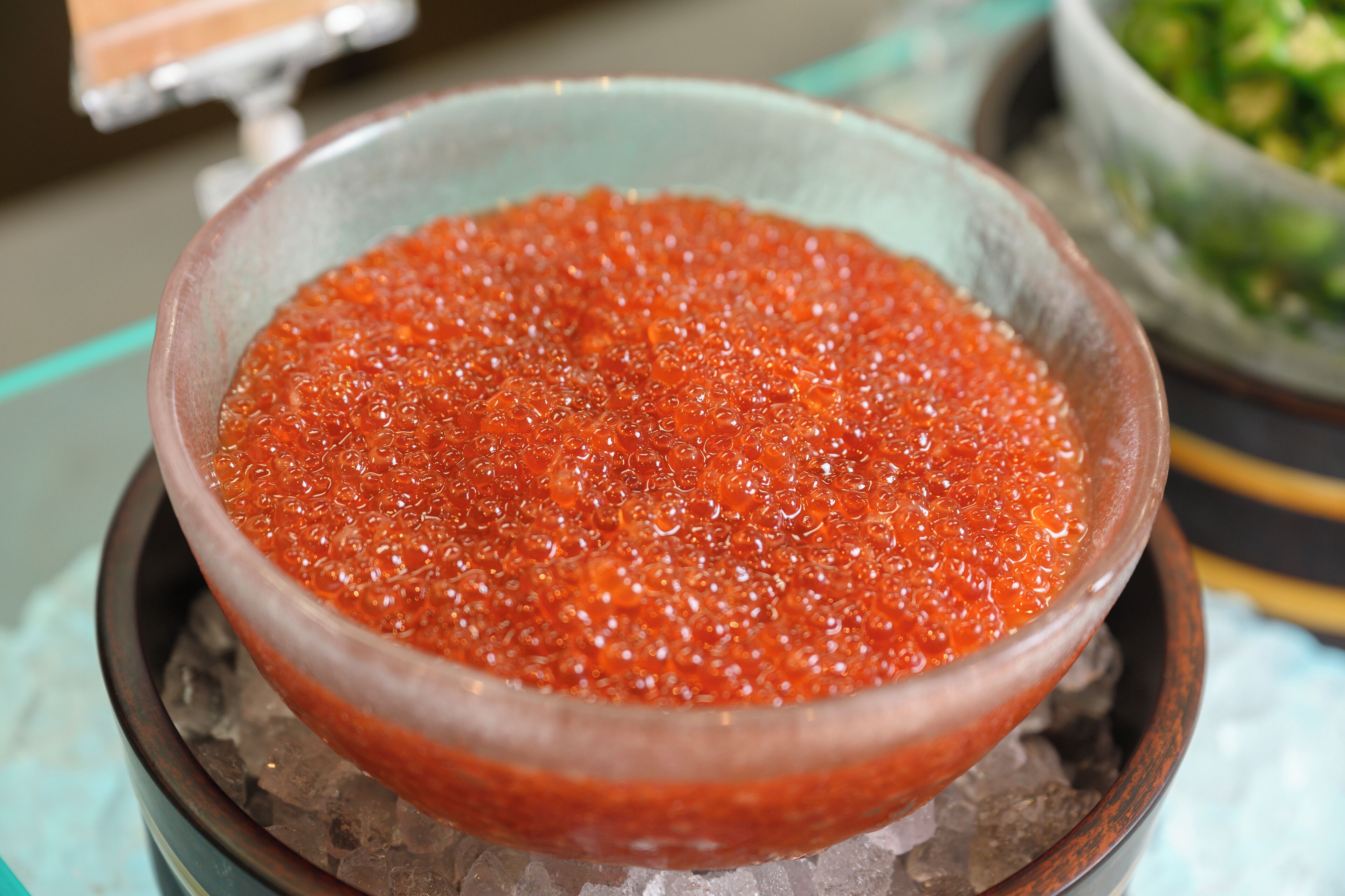 A bowl of red caviar on a bed of ice.