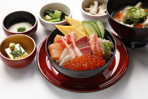 Una variedad de platos japoneses, incluyendo sashimi, sushi y otras exquisiteces marinas.