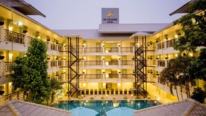 Un hotel con varios balcones, una piscina central y un cartel que dice "DE CHARME HOTEL".