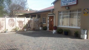 Un bâtiment portant une enseigne indiquant « CHAMBRES D’HÔTES ET RESTAURANT EN FRANCHISE ».