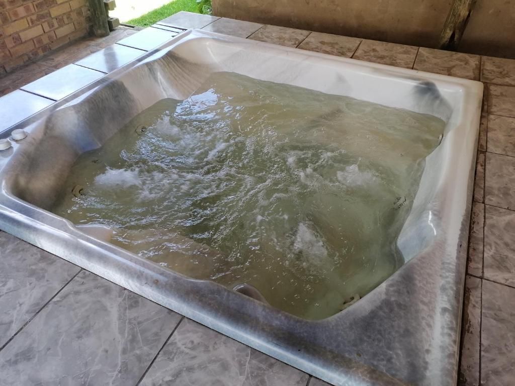 A rectangular hot tub with water, surrounded by a tiled floor.