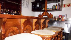 Un espace bar avec des chaises en bois et un comptoir.