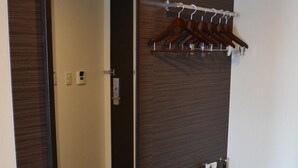 A hotel bathroom with a large mirror, a towel rack, a drying rack, and a row of slippers. - Shizutetsu Hotel Prezio Numazu (Numazu)