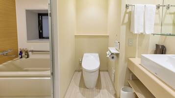 A modern bathroom with a bathtub, toilet, and a glass shower enclosure.