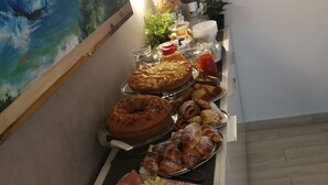 A buffet table with various food items including pastries, meats, and fruits. - B&B Il Mare degli Dei (Letojanni)