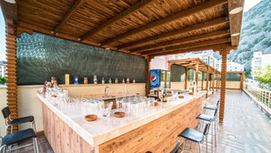 Un espace bar en bois avec un grand comptoir, des tabourets de bar et une enseigne Pepsi.