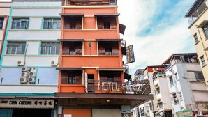 Un hotel de varios pisos con balcones, un cartel que indica que es el Hotel 2 y una fachada visible en la planta baja.