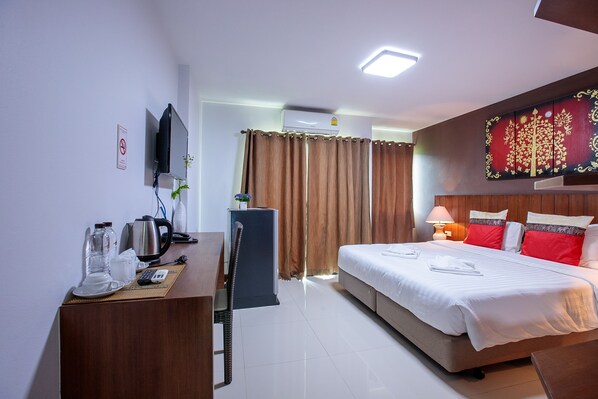 Une chambre d’hôtel avec un lit, un bureau et une télévision.