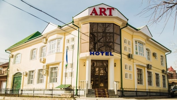 Een geel gebouw met een bord waarop 'ART HOTEL' staat.
