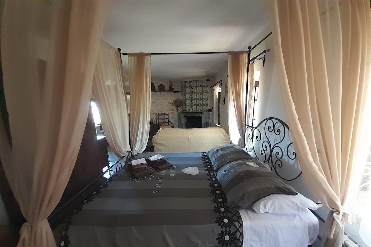 A room with a bed, curtains, and a headboard.