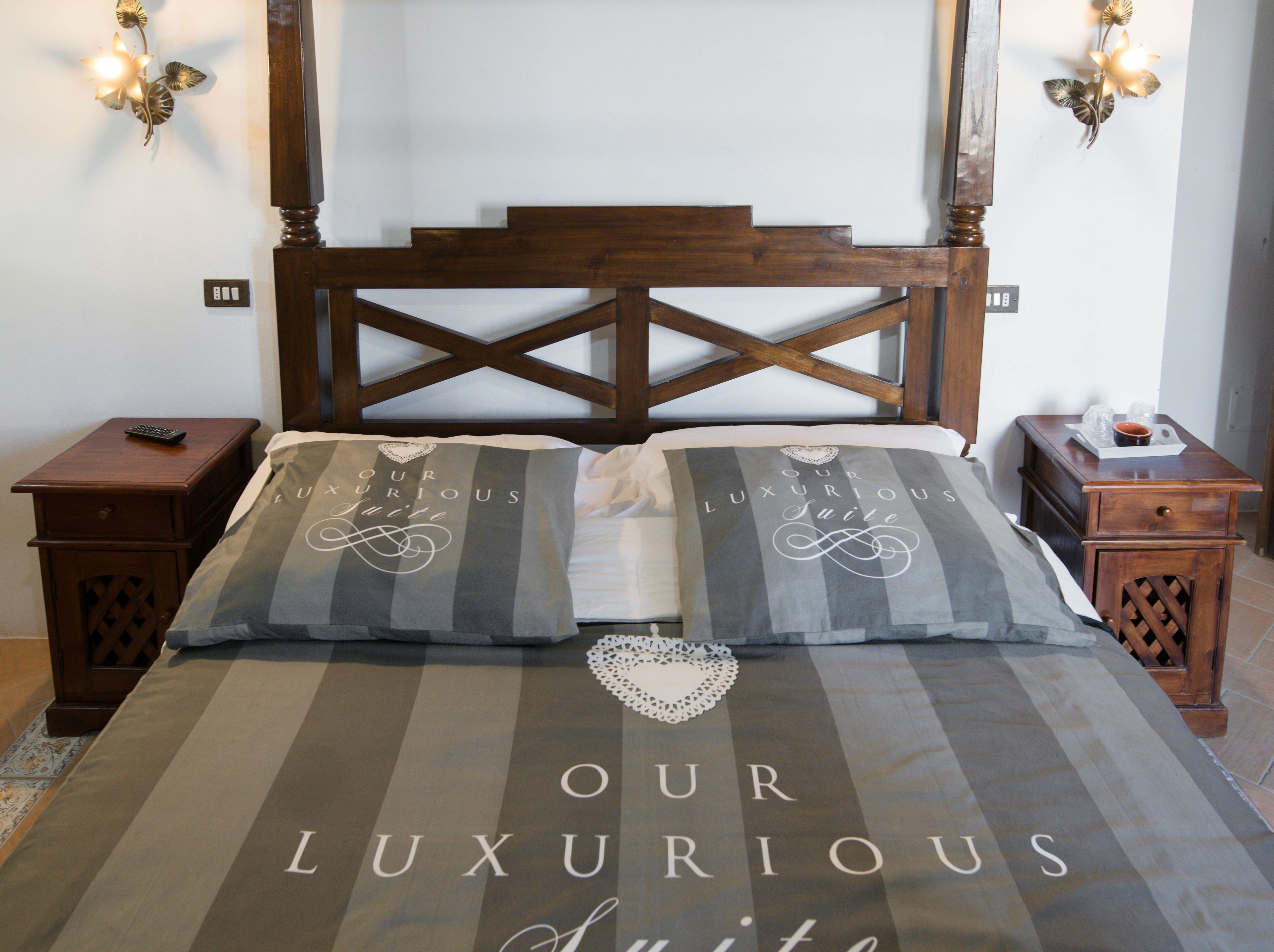 Una cama con colcha a rayas y almohadas que dicen "OUR LUXURIOUS Suite".
