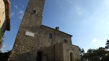 A historic stone building with a prominent tower and arched windows.
