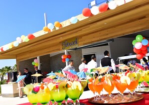 En bar och restaurang som heter ”Febeach”, med färgglada ballonger och parasoller på taket.